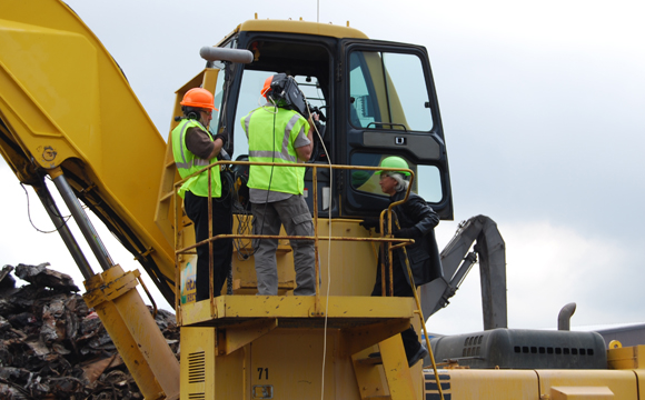 Cameras roll as "Sci-Fi Science: Physics of the Impossible" host Dr. Michio Kaku prepares to get into a crane at Gershow Recycling's Medford facility to operate one of the super magnets.