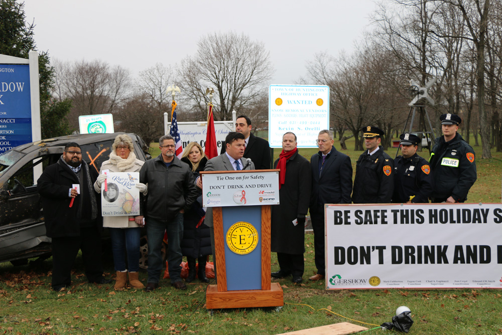 John Zaher (standing behind podium), Representative, Gershow Recycling, speaks during a press conference announcing the Town of Huntington’s anti-drunk and distracted driving campaign on December 16.