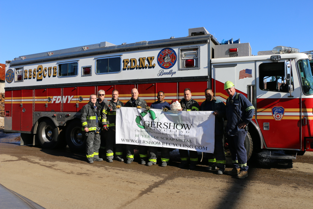 Eric Kugler (second from left) and Scott Kolesari (right), Managers, Gershow Recycling, pose with members of FDNY’s Rescue Company Number 2, who received five turkeys from Gershow.