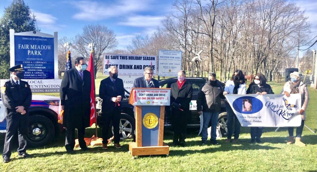 Kevin Gershowitz (standing behind podium), President, Gershow Recycling, speaks during a press conference announcing the Town of Huntington’s anti-drunk and distracted driving campaign on December 7. Also pictured (left to right): William Scrima, Officer, Suffolk County Police Department; Chad Lupinacci, Supervisor, Town of Huntington; Mark Cuthbertson and Edmund J.M. Smyth, Council Members, Town of Huntington; William Holden, husband of Karen Holden, who was killed by a drunk driver; Joanne Sperando, Ms. Holden’s friend; Lynne Rogers Pallmeyer, Ms. Holden’s sister; and Liisa Anderson, Ms. Holden’s cousin.
